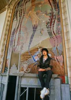 Richard Keit photographed in 1986 in front of the massive external mural he reproduced in tile, to replace the painted original, courtesy <i>RTK Studios</i> (JPG)